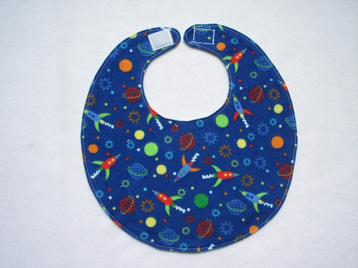 Baby bib, four soft layers, reversible, blue with bright little spaceships