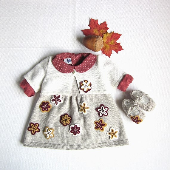 A knitted baby dress with a little coat full of flowers