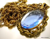 I recently purchased this necklace and recognized the embossed twisted rope chain immediately as Miriam Haskell. Unsolicited, the seller told me that it was Miriam Haskell, that it originally had a hang tag and that the hang tag fell off and she lost it. While I'd love to have found this with the tag, I accepted the seller's explanation because of the chain. This is a gorgeous pendant necklace! Absolutely in fashion as an oversized necklace - gorgeous without glitter. The brass framed pendant measures 3-1/8 inches with the bail and 2 inches wide. The embossed, twisted rope chain slips over the head and measures 30 inches in total. In great condition with light wear to the table of the blue glass that is not evident when worn. Handsome, classic and Haskell.