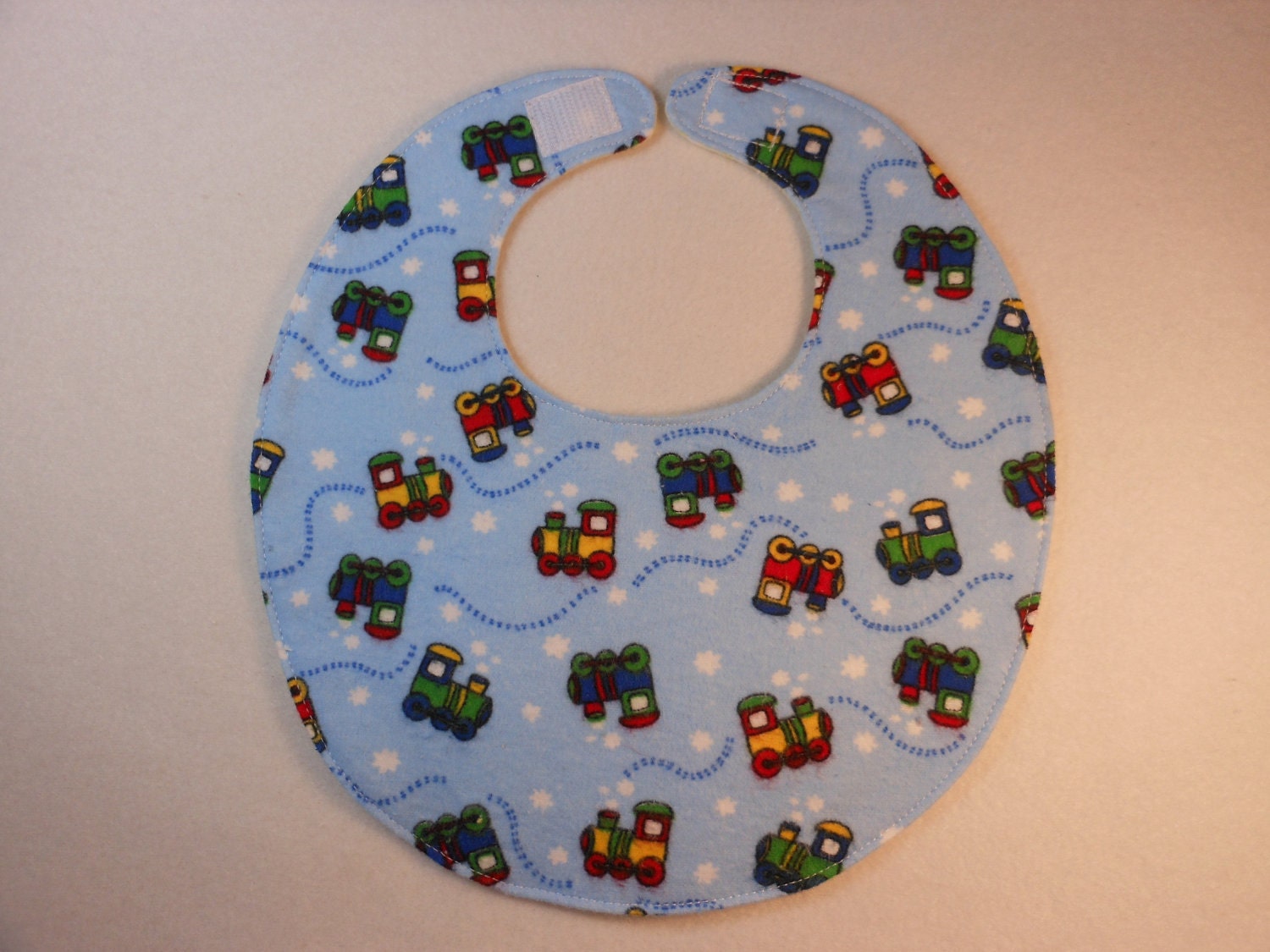 Baby bib, four soft layers, reversible, blue with bright little choo choos