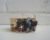 Vintage shiny brass cuff bracelet with a cluster of black crystals in the center, recycled vintage pieces, crystals, rhinestones, flowers &