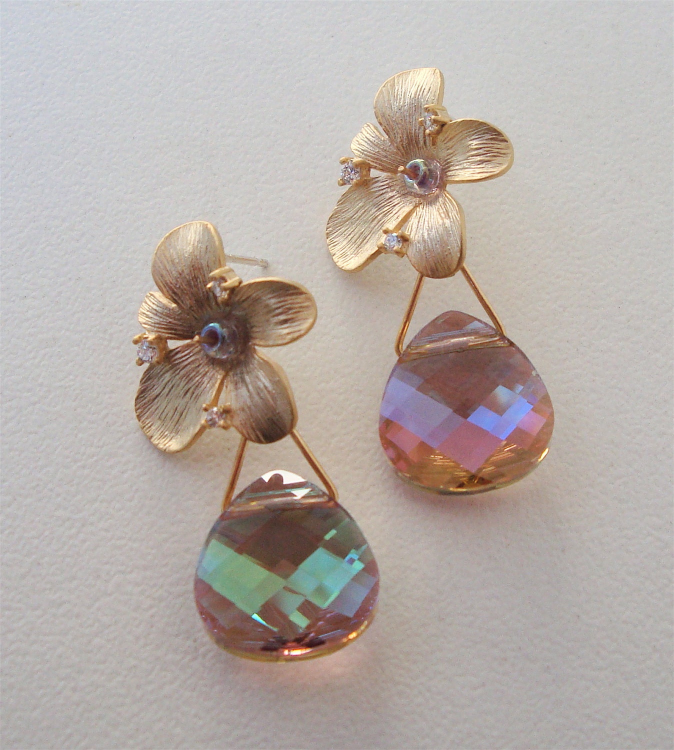 Matte gold over brass Orchid floret earring with a beautiful pastel swarovski crystal briolette. The flower is adorned with tiny cz's