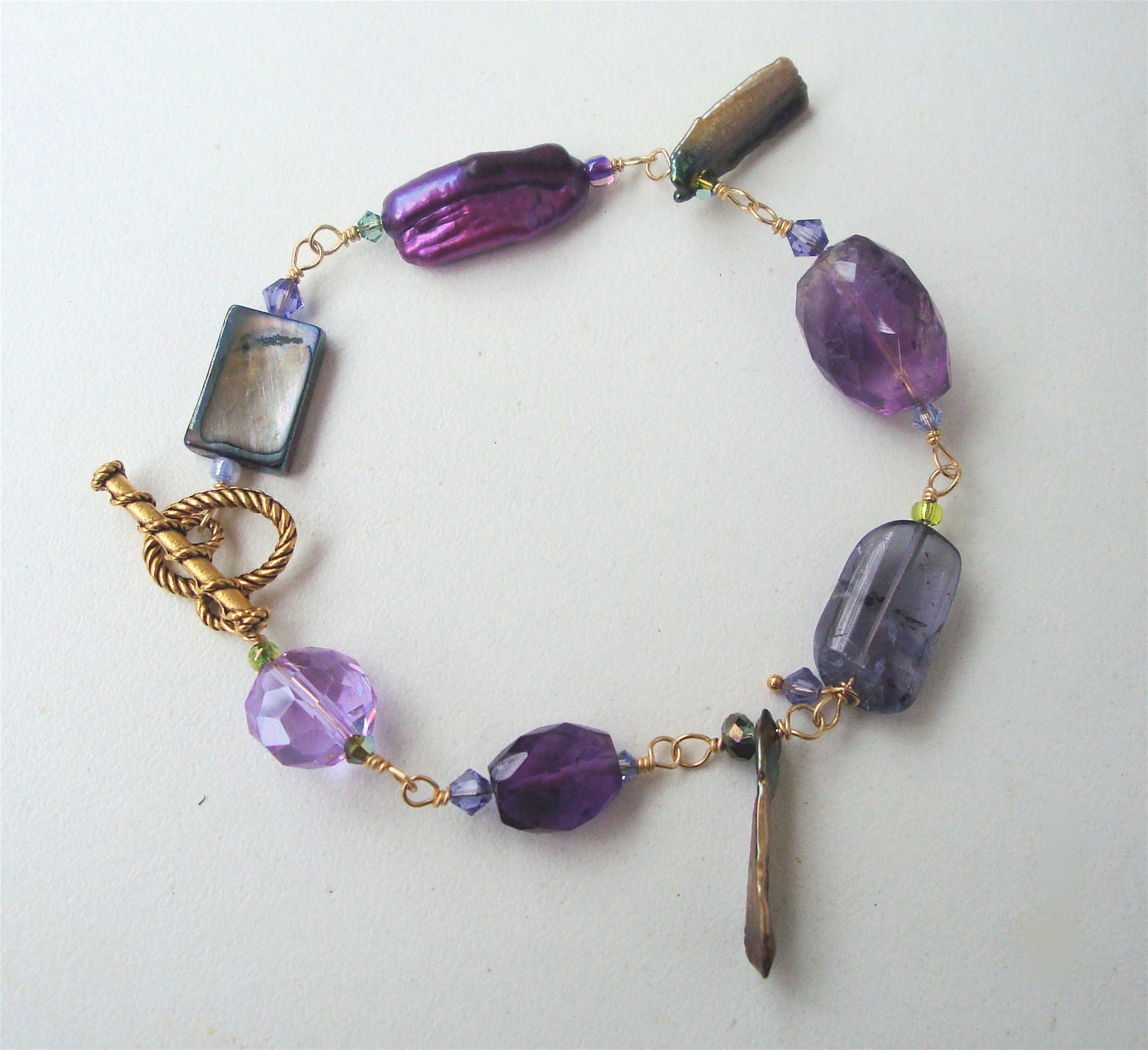 Beautiful and feminine natural gemstone bracelet consisting of Amethyst, Iolite, Dyed Fresh Water Pearls, Mother of pearl and Swarovski Crys