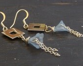 A graveyard filled with windows. Light blue flower, fringe and window earrings