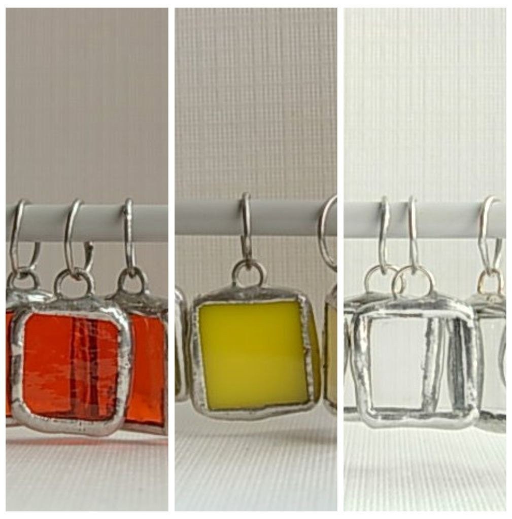 Stitch markers in stained glass in shades of orange, yellow and clear. Sample pack.
