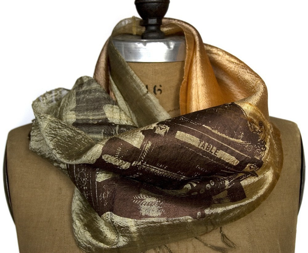 Image of an olive and burnt orange scarf draped over the shoulders of a mannequin