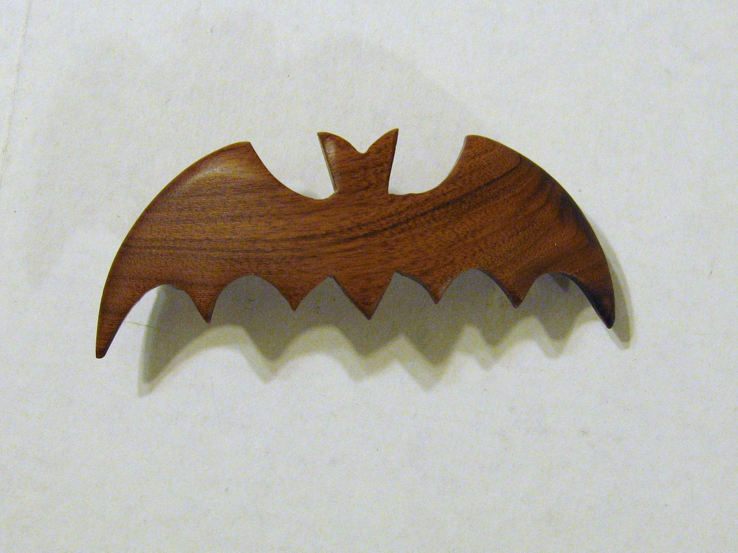 A rosewood hair clip in the shape of a bat