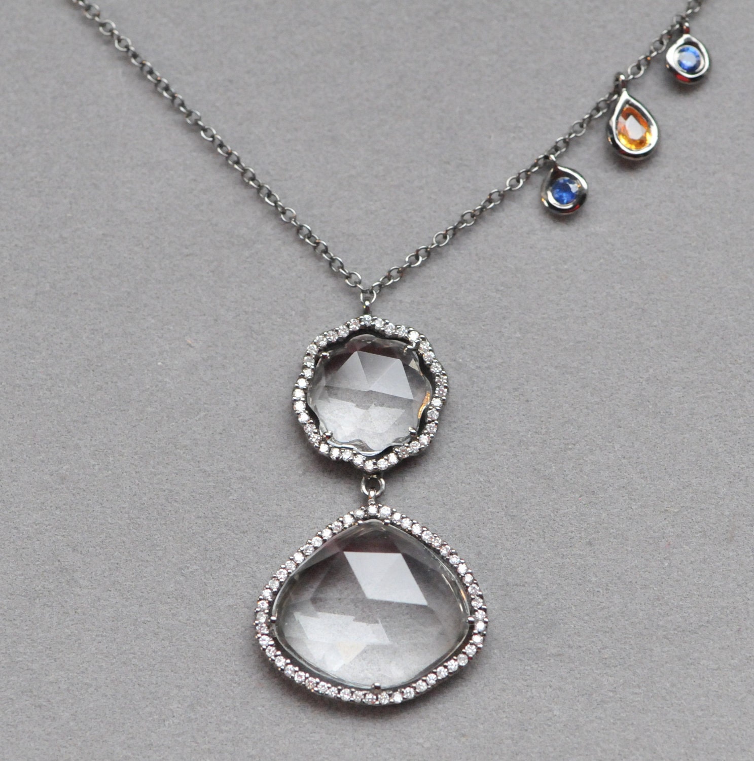 pave diamond black rhodium pendant with white topaz and sapphire in 18k gold