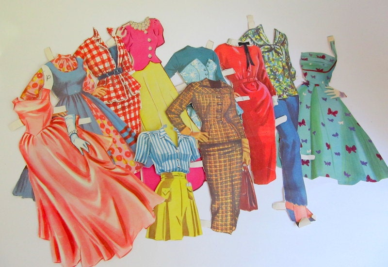 Several vintage paper dolls outfits including paper doll dresses and trousers
