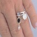 Sterling silver charm ring with pattern motif and faceted garnet and white seed pearl
