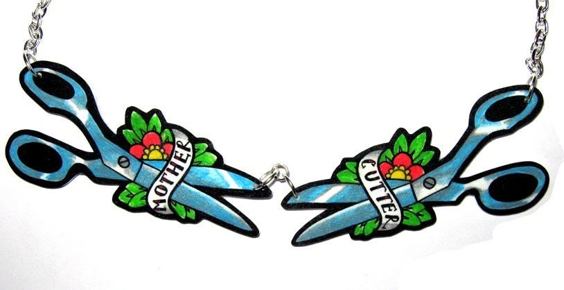 Two pairs of scissors are either side with some pretty flowers and tattoo