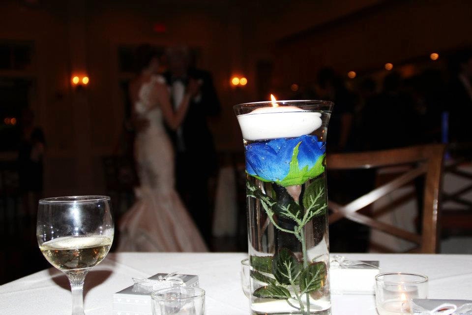 These floating candle centerpieces include a blue fabric rose suspended in 