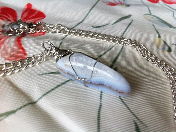 arvia. a wire-wrapped blue lace agate stone pendant on silver chain.
